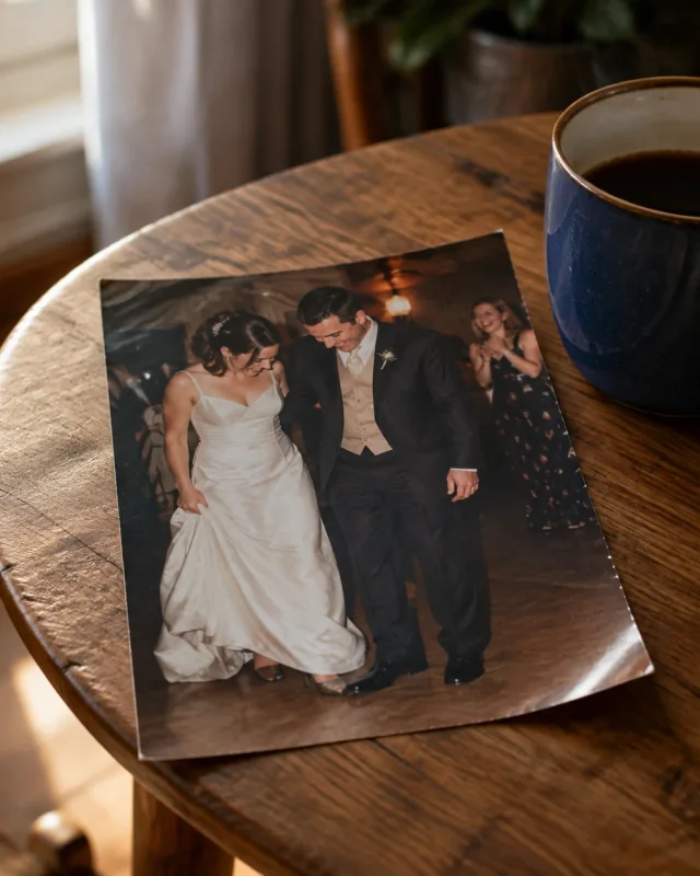 A loose wedding photograph of a couple looking down at their first dance, beside a blue coffee cup
